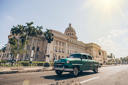 November 26, 2019, Havana, Cuba: Old classic American cars green color rides in front of the Capitol.