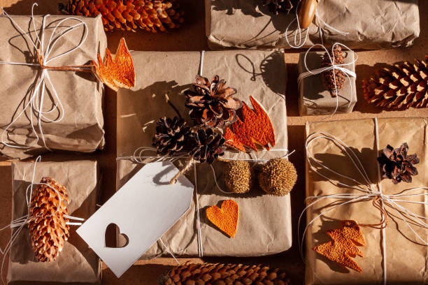 zero waste christmas knolling flat lay with hard shadows. hand crafted eco gift, natural new year jute decorations top view. kraft paper wrapping without plastic concept. orange zest tree,hearts,cones - gift orange green package imagens e fotografias de stock
