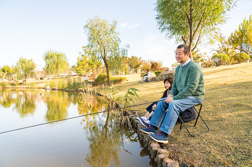 Chinese family fishing in a park.
