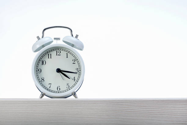 istock Alarm clock on wooden shelf against grey background with copy space. 1282132343