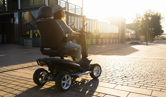 Mujer turista montando un scooter eléctrico de movilidad de cuatro ruedas photo