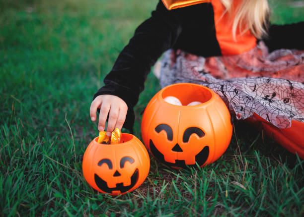 istock a child's hand reaches for candy in a pumpkin-shaped candy basket 1282137335