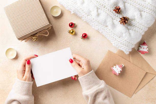 istock woman's hands holding blank card and xmas decorations on beige background 1282137519