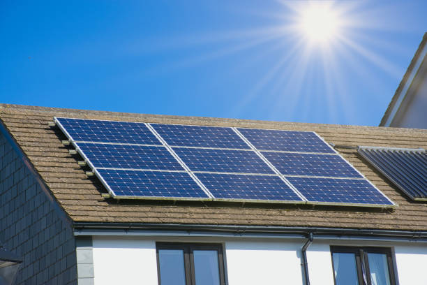 sun rays over a Cornish house with photovoltaic power plant Photovoltaic power plant on the roof of a Cornish house on a sunny day - Solar Energy concept of sustainable resources solar power station solar panel house solar energy stock pictures, royalty-free photos & images