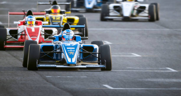Racing drivers driving open-wheel single-seater racing car cars on racing track.