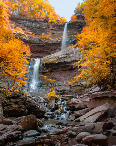 Large waterfall surrounded by vibrant fall foliage color. Kaaterskill Falls, Woodstock New York