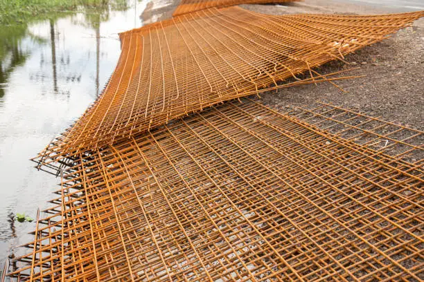 The rusty steel grid in pattern,Rusty construction metal mesh. Rusty Metal armature net for  road infrastructure  metal rebar for construction,Sites Soak in Water and Rust.