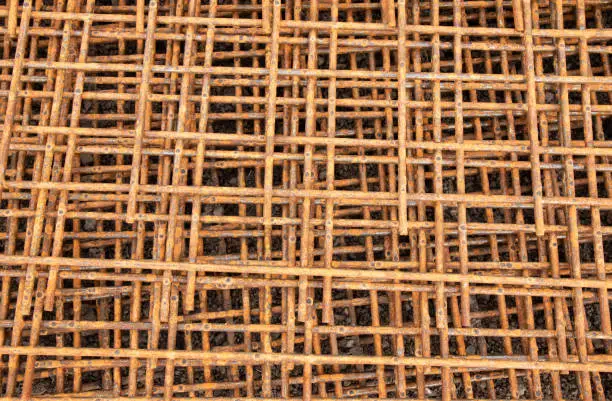 The Closeup rusty steel grid pattern,Rusty construction metal mesh for  road infrastructure  metal rebar for construction,Sites Soak and Rust,on Soil road construction.