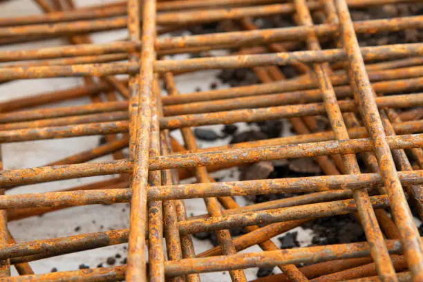 The Closeup rusty steel grid pattern,Rusty construction metal mesh for  road infrastructure  metal rebar for construction,Sites Soak and Rust,on Soil road construction.