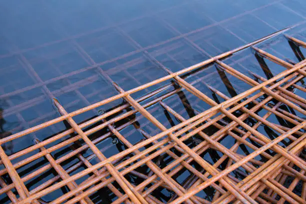 The rusty steel grid in pattern,Rusty construction metal mesh. Rusty Metal armature net for road infrastructure metal rebar for construction,Sites Soak in Water and Rust.