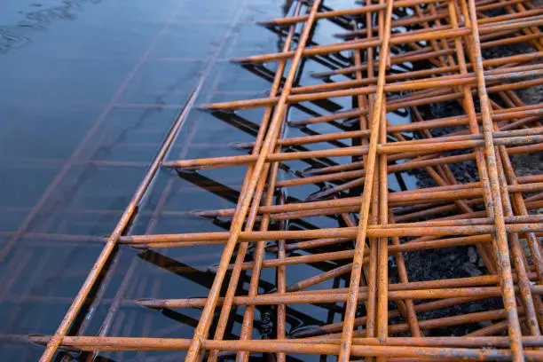 The rusty steel grid in pattern,Rusty construction metal mesh. Rusty Metal armature net for road infrastructure metal rebar for construction,Sites Soak in Water and Rust.