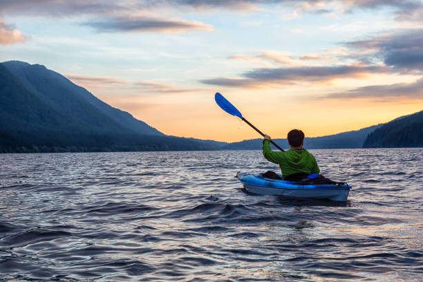 Beautiful View of Person Kayaking on Scenic Lake at Sunset Beautiful View of Person Kayaking on Scenic Lake at Sunset surrounded by Mountains in Canadian Nature. Taken in Golden Ears Provincial Park, near Vancouver, British Columbia, Canada. alouette lake stock pictures, royalty-free photos & images