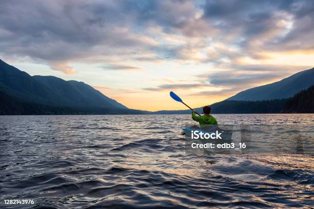 Beautiful View Of Person Kayaking On Scenic Lake At Sunset Stock Photo - Download Image Now