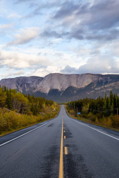 istock View of Scenic Road surrounded by Trees and Mountains 1282144151