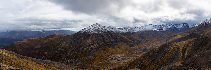 Panoramic View of Scenic Landscape, Valley and Mountains in Canadian Nature. Season change from Fall to Winter. Taken in Tombstone Territorial Park, Yukon, Canada.