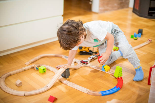 istock Beautiful little boy playing with a railroad train toy. 1282147100