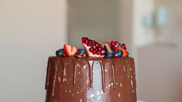 istock chocolate cake decorated with strawberries, blueberries and a pomegranate on an orange background 1282147521