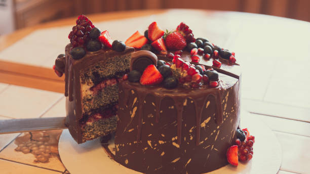 istock A chocolate cake decorated with strawberries, blueberries and a pomegranate on an orange background 1282147613
