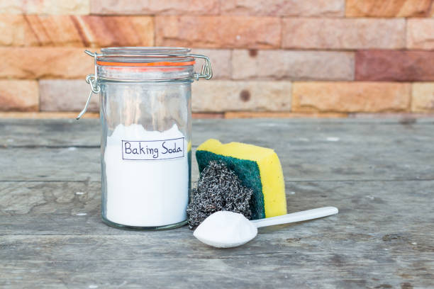 istock jar and a spoonful of baking soda for cleaning kitchenware on a wooden kitchen table. 1282147660