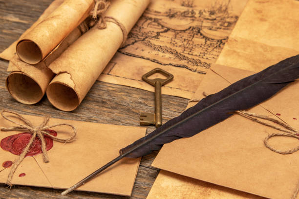 istock The surface of the old wooden table. On the table are old scrolls, an old map, an envelope with a seal, an iron key to the lock 1282149010