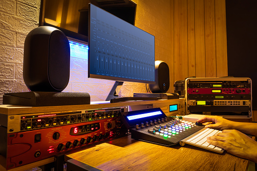 sound engineer hands working on digital professional audio equipment in recording, editing, broadcasting studio