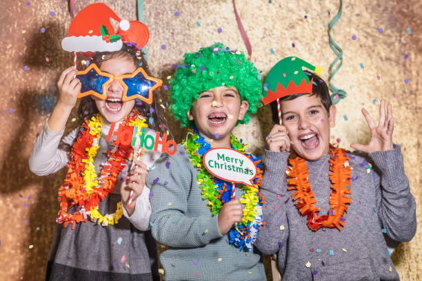 tre bambini che festeggiano il giorno di natale di capodanno a casa - 12 13 years immagine foto e immagini stock