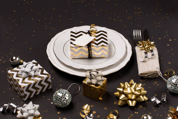 istock Christmas table setting. Gold and silver decoration with gift and glitter. Selective focus, black background. 1282151642