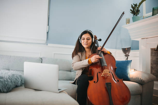 istock Smiling girl playing a cello at home 1282152142