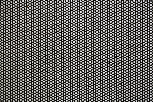 istock Thin black metal sheet with small through holes, background 1282153130