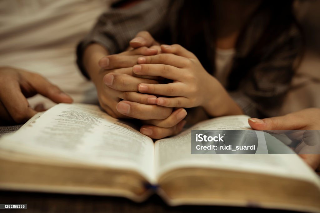 a kid reading the holy bible a kid reading the holy bible with guide by parents Praying Stock Photo