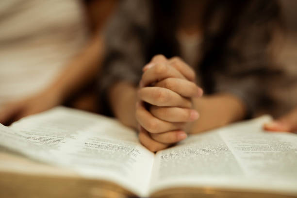 a kid reading the holy bible a kid reading the holy bible with guide by parents catholicism stock pictures, royalty-free photos & images