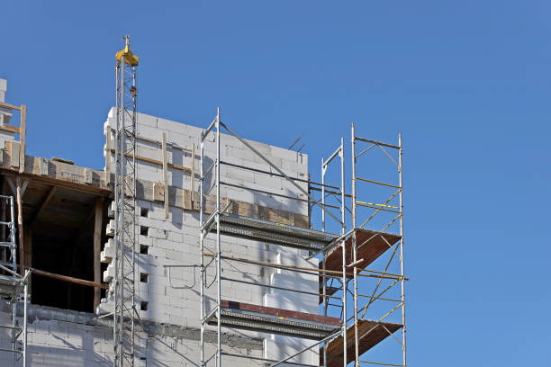 istock Modern construction forests for workers are leaning against the facade of a high-rise building under construction. Repair and construction work at heights. Safety of human labor. Danger of heights 1282156185