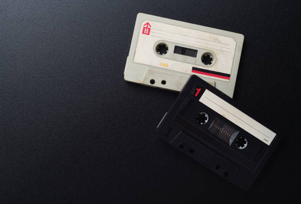 istock Two old white and black vintage audio cassettes on a black background, top view. 1282156936