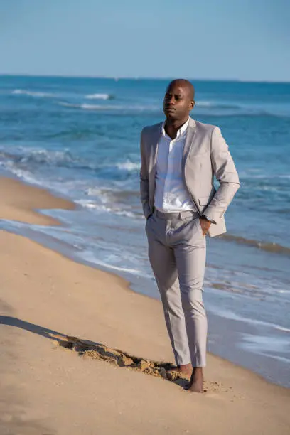 African American ethnicity elegant businessman suit man walking on beach relaxed
