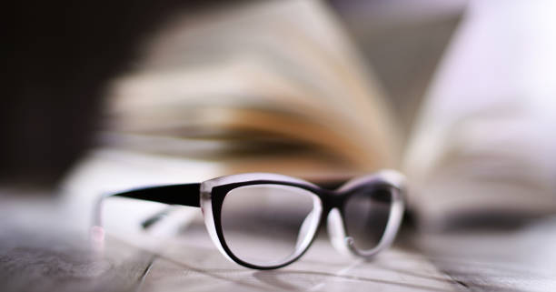 istock Composition with glasses and open book on the table 1282159056