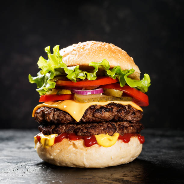 istock Fresh tasty double hamburger on black background. 1282159392