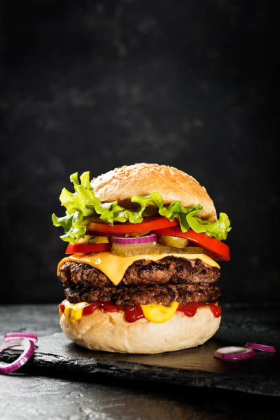 istock Fresh tasty double hamburger on black background. 1282159397