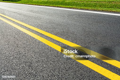 istock Freshly painted lane markers on a newly paved road 1282160601