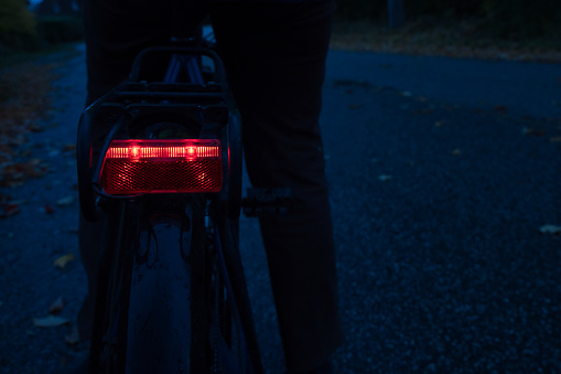 red bicycle bike rear light in the darkness, focus on rear light