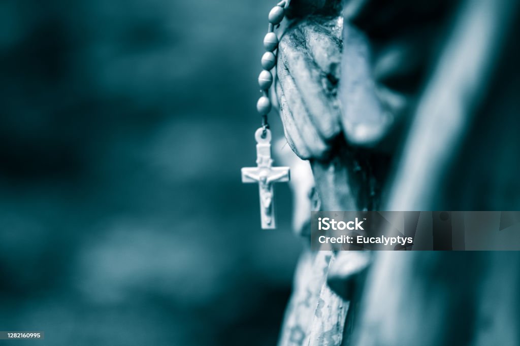 Rosary, holy cross Rosary on wooden statue of Mary in the Forest near Krakow. Poland. No people. Close shot. Monochrome. Rosary Beads Stock Photo