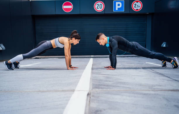 istock Fit young man and woman doing push-ups 1282162893