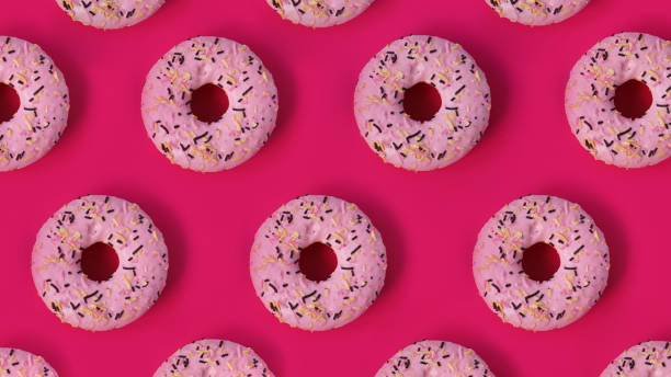 istock Festive creative pattern of rows of donuts on pink background 1282166015