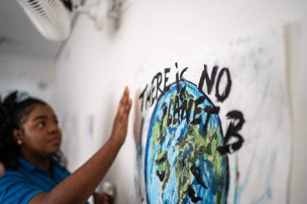 student fixiert in der wand ein poster über umweltfragen - es gibt keinen planeten b - school gymnasium fotos stock-fotos und bilder