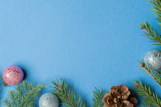 istock Fir, spruce branches, pine cones and Christmas tree toys on blue background with copy space 1282168461