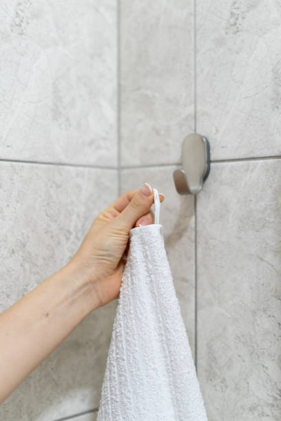 istock Woman hangs white bath towel on a hook 1282168986