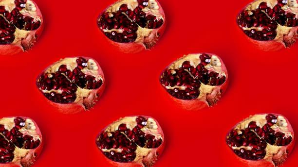 istock Pattern of red pomegranates in rows on red background, fruit lines backdrop 1282169051