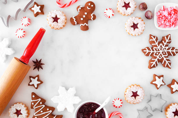 Christmas baking frame with cookies and sweets, above over a white marble background