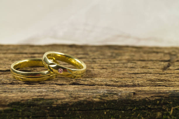 istock Two wedding rings on wooden background. 1282170445
