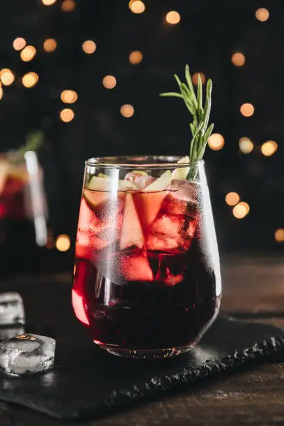 A glass of sangria with ice. Red wine with apples and spices, vertical photo. High quality photo