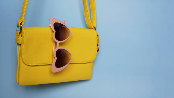 istock Yellow bag and heart-shaped sunglasses on blue background 1282171897